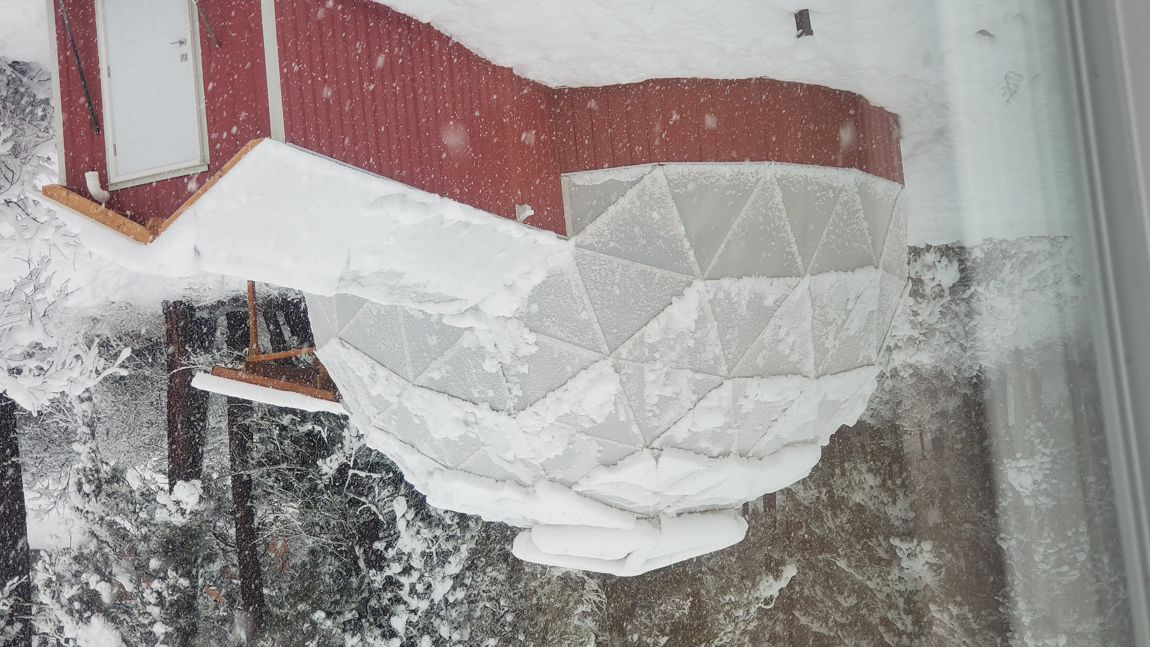 The greenhouse dome surrounded by fresh snow on a clear winter day